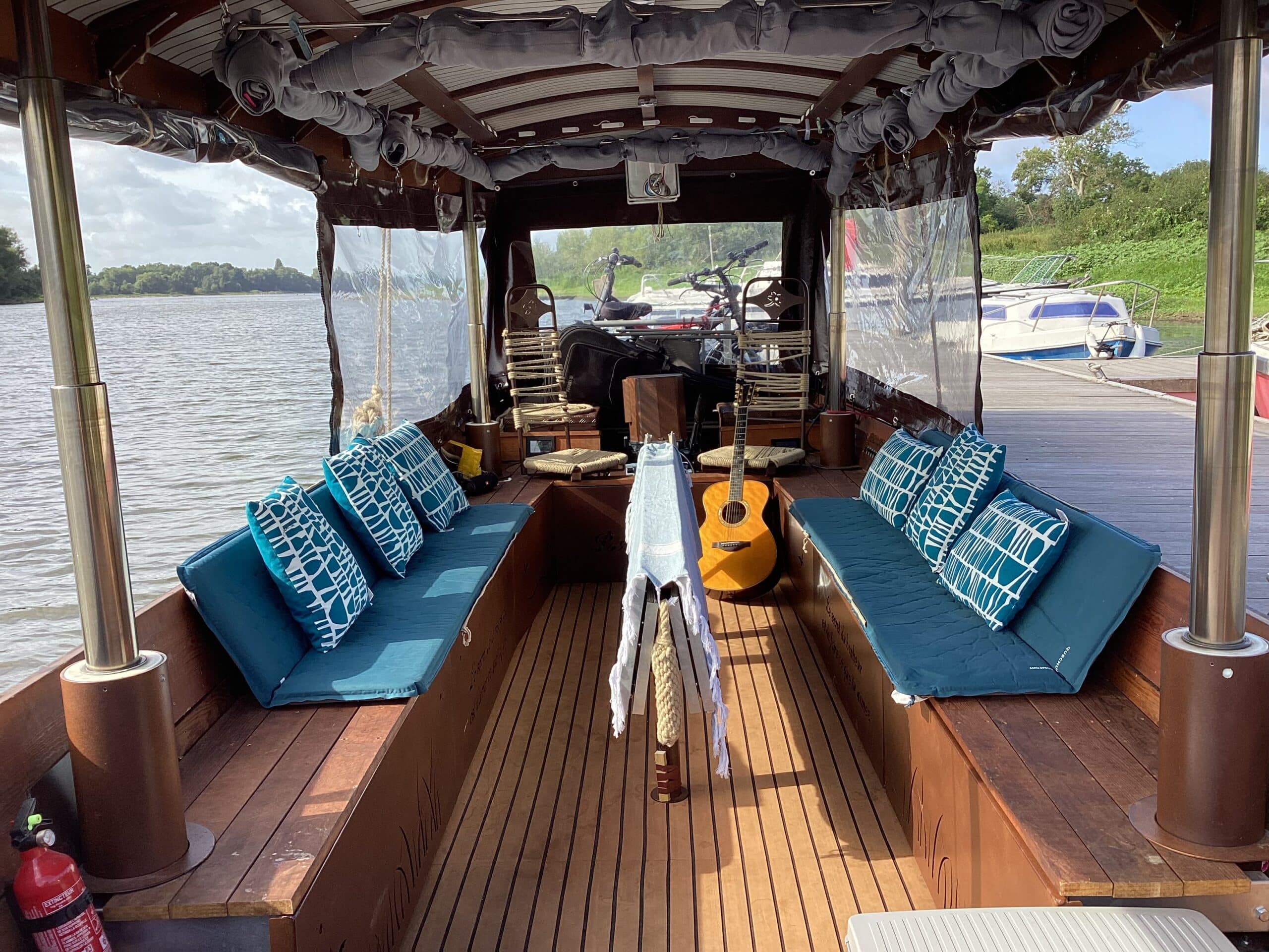 Plate de Loire - Intérieur bateau avec coussins et guitare.